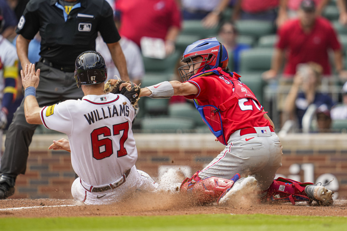 Sep 20, 2023; Cumberland, Georgia, USA; Philadelphia Phillies catcher Garrett Stubbs (21) tags out Atlanta Braves pinch runner Luke Williams (67) preventing the game winning run during the ninth inning at Truist Park.